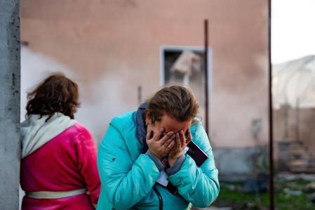 A woman reacts in the courtyard of a damaged building following a missile attack in Odesa region