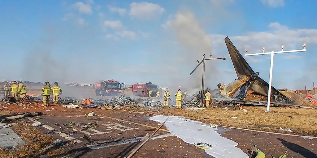 The plane slides down the runway and hits a fence, causing a violent explosion.