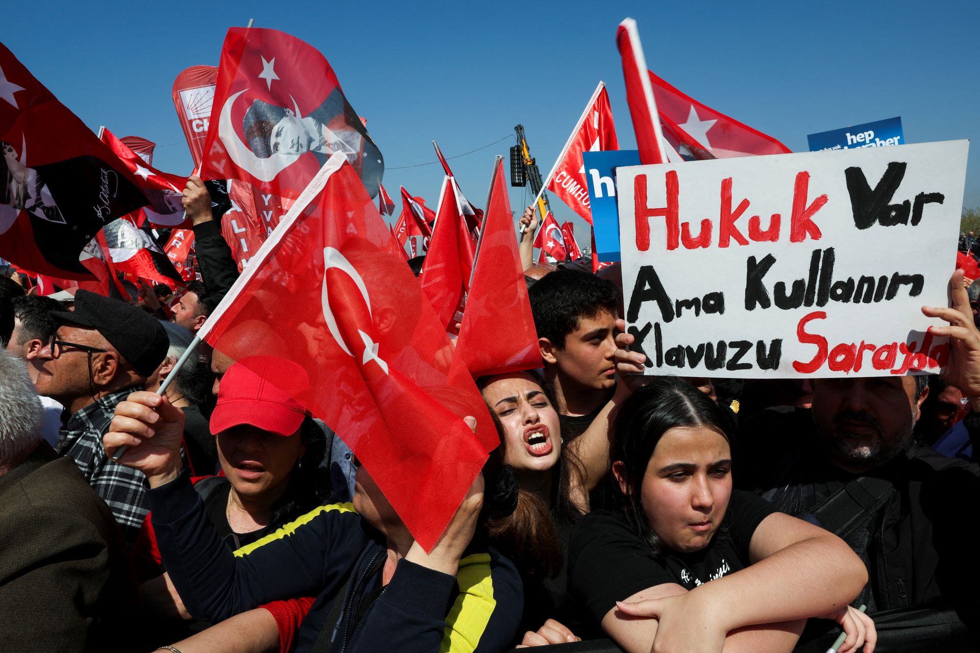 Protesters with the Turkey flag and a sign that says 'there is law, but the user's manual is in the palace'